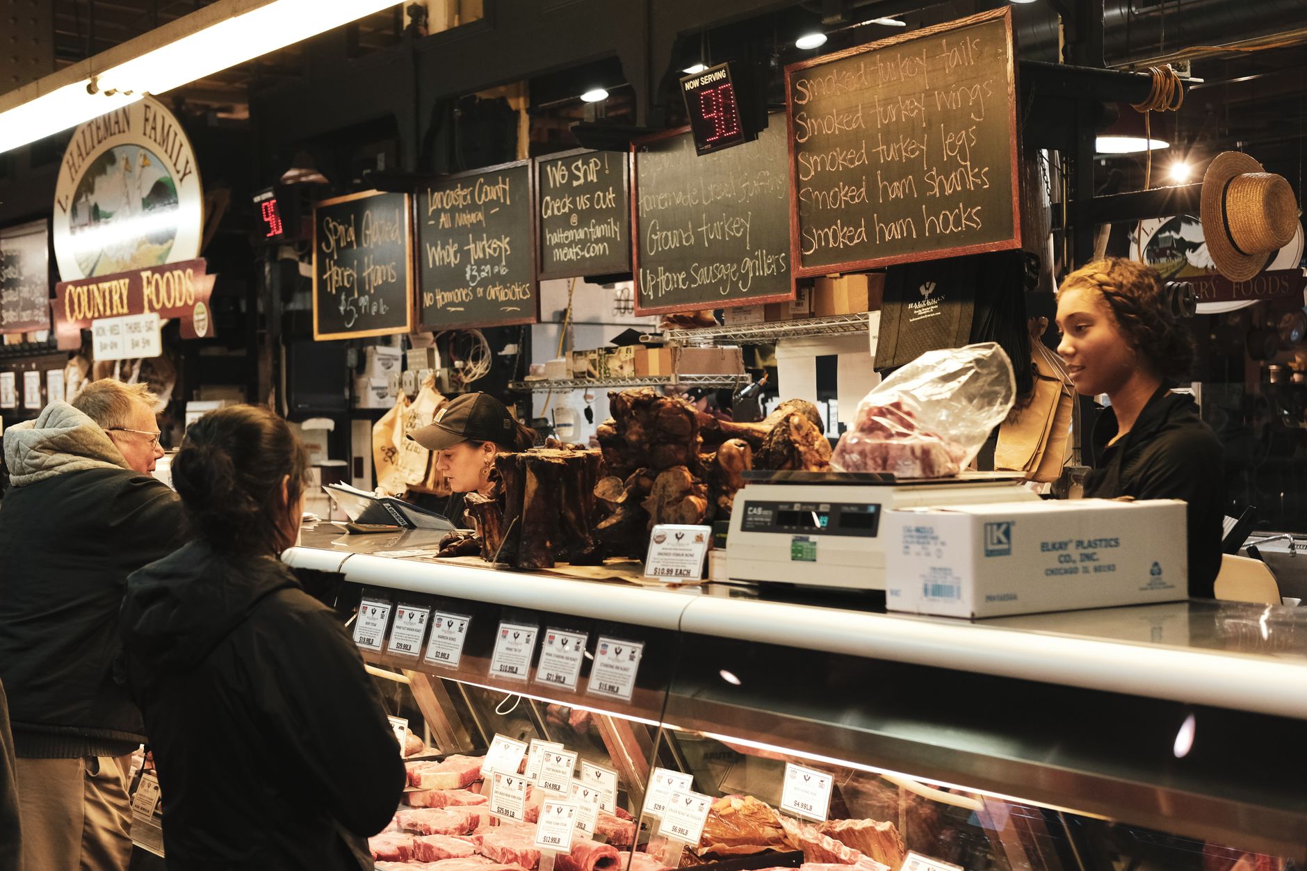 A butcher at work behind the counter of a shop